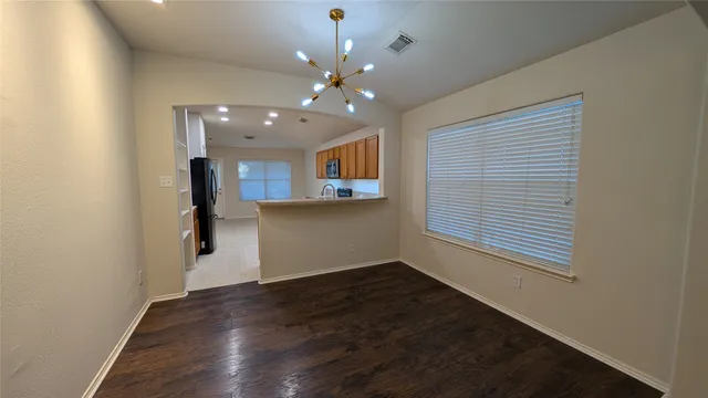 a view of a room with wooden floor and chandelier