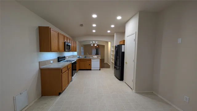 a large kitchen with a refrigerator and a sink