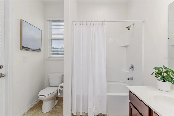 a white toilet sitting next to a white tub