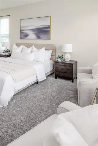 a spacious bedroom with a bed and a lamp