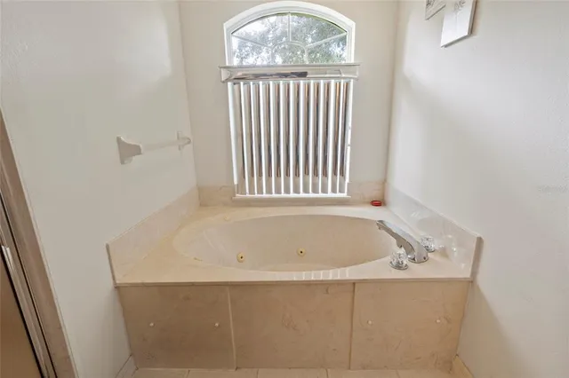a white bath tub sitting in a bathroom next to a window