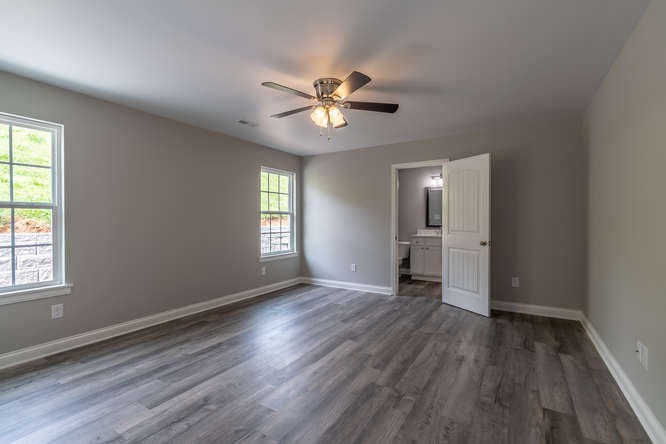 700 Spring Park Road Knoxville, TN 37914 - Photo 11 of 25 an empty room with wooden floor a ceiling fan and windows