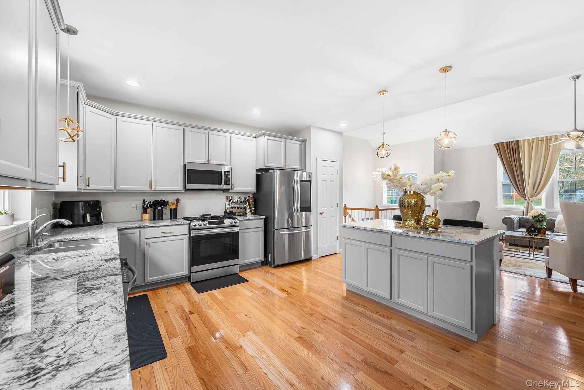 5 Oak Ridge Road Middletown, NY 10940 - Photo 10 of 24 a kitchen with stainless steel appliances a stove top oven a sink a refrigerator white cabinets and wooden floor