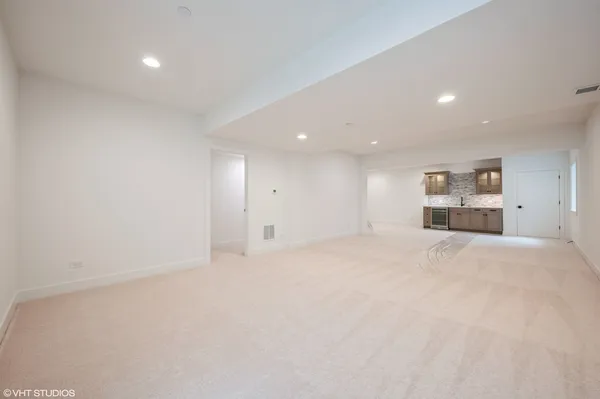a view of empty room with kitchen and window