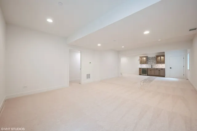 a view of empty room with kitchen and window