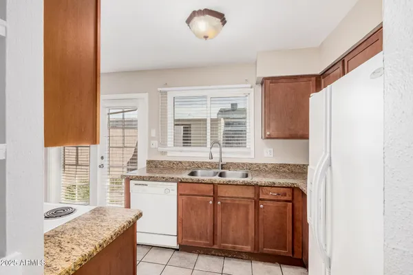 a kitchen with granite countertop cabinets stainless steel appliances a sink and a window