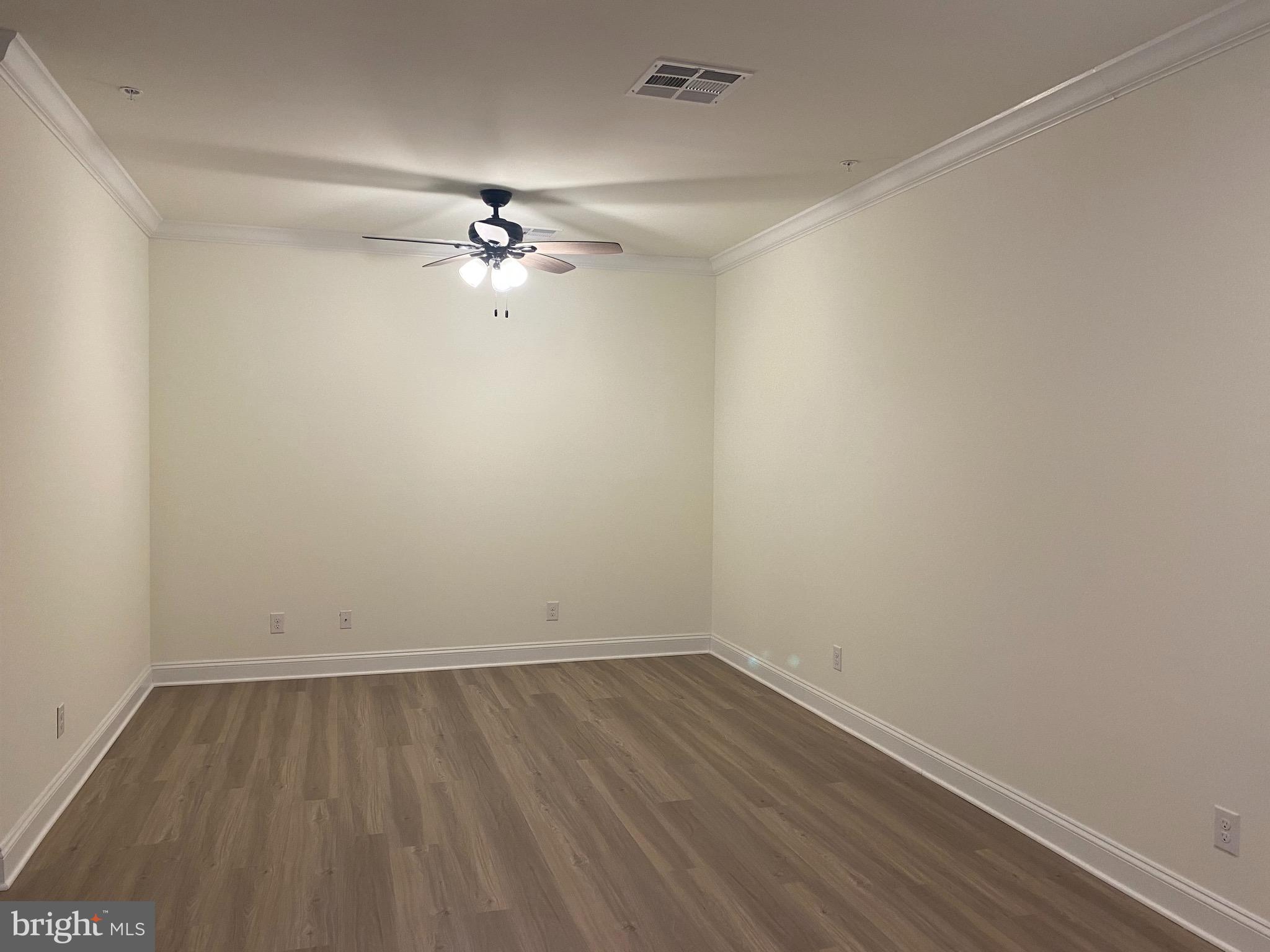 1812 Main Street, Unit 203 Chester, MD 21619 - Photo 10 of 24 a view of a room with wooden floor and a ceiling fan