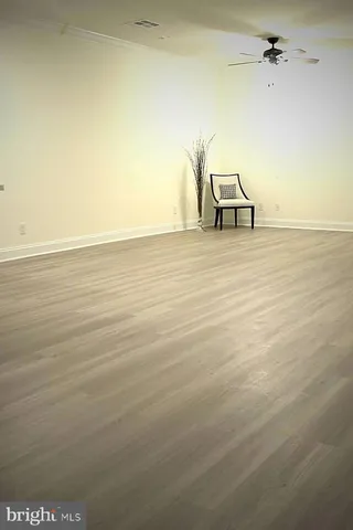 a view of a room with wooden floor and a ceiling fan
