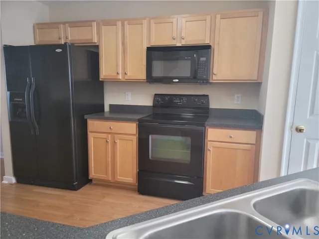 a kitchen with stainless steel appliances granite countertop a refrigerator stove and sink