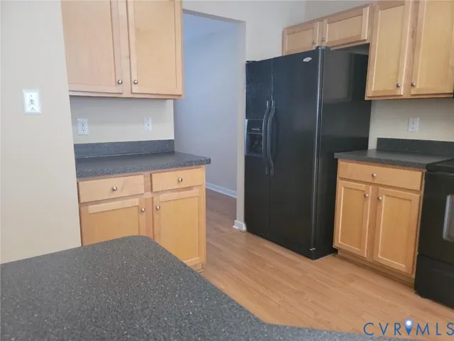 a kitchen with granite countertop white cabinets and refrigerator