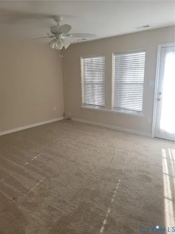 an empty room with chandelier fan