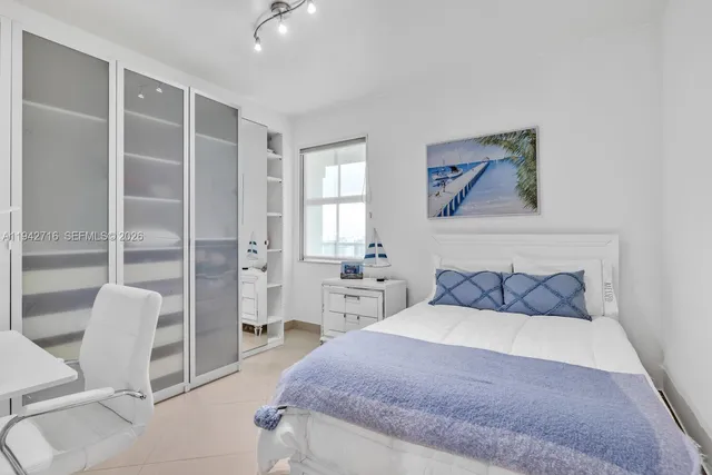 a bedroom with a bed and a large mirror