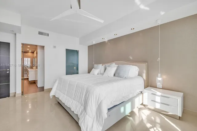 a bedroom with bed mirror and window