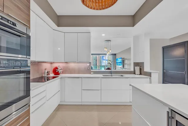 a kitchen with stainless steel appliances granite countertop a sink and a refrigerator