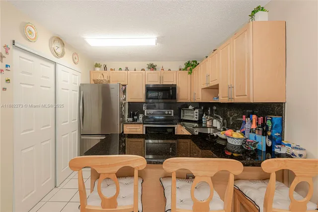 a kitchen with stainless steel appliances granite countertop a refrigerator and a stove top oven