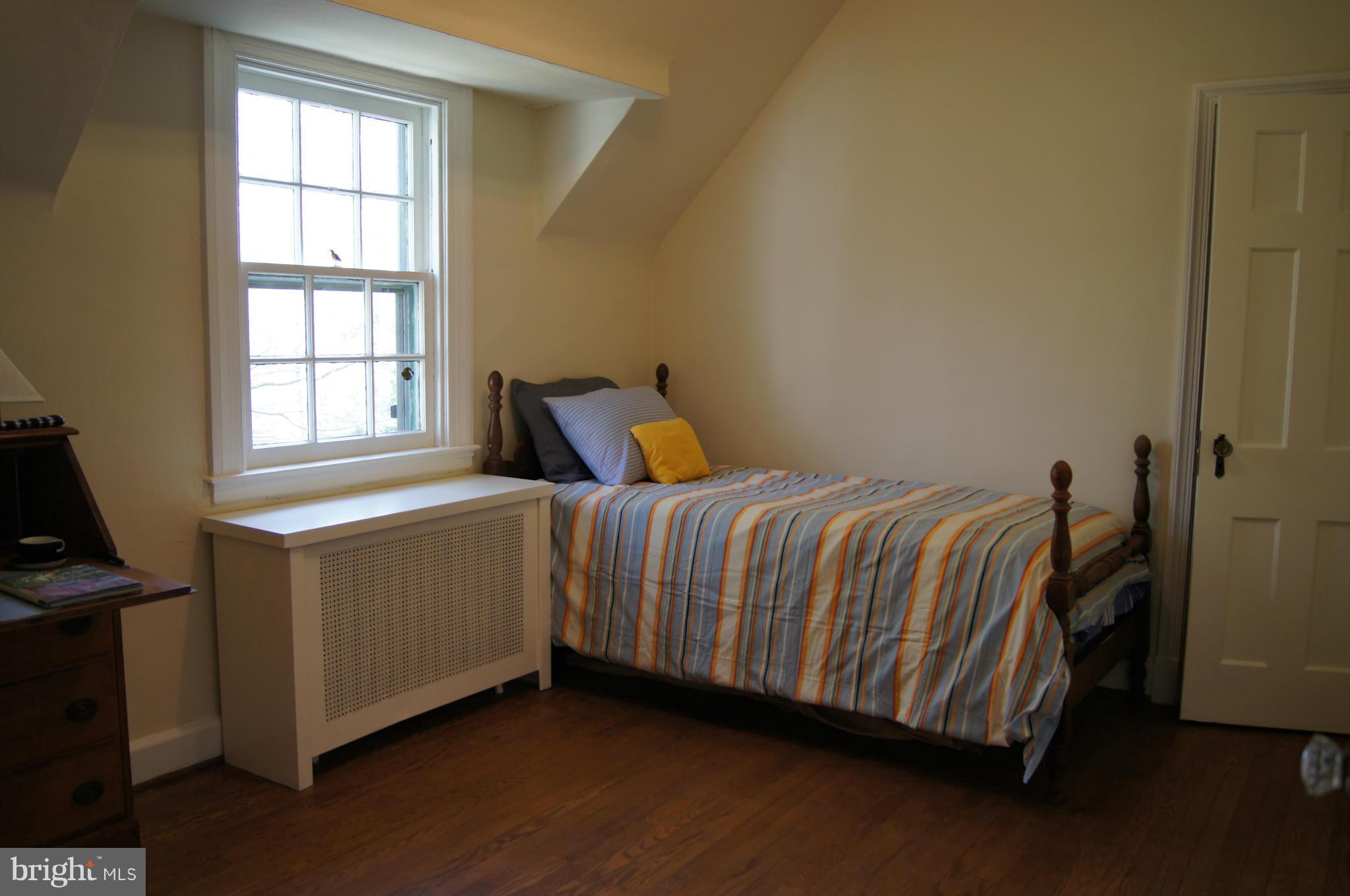 7101 Copeleigh Road Baltimore, MD 21212 - Photo 21 of 30 a bedroom with a bed and wooden floor