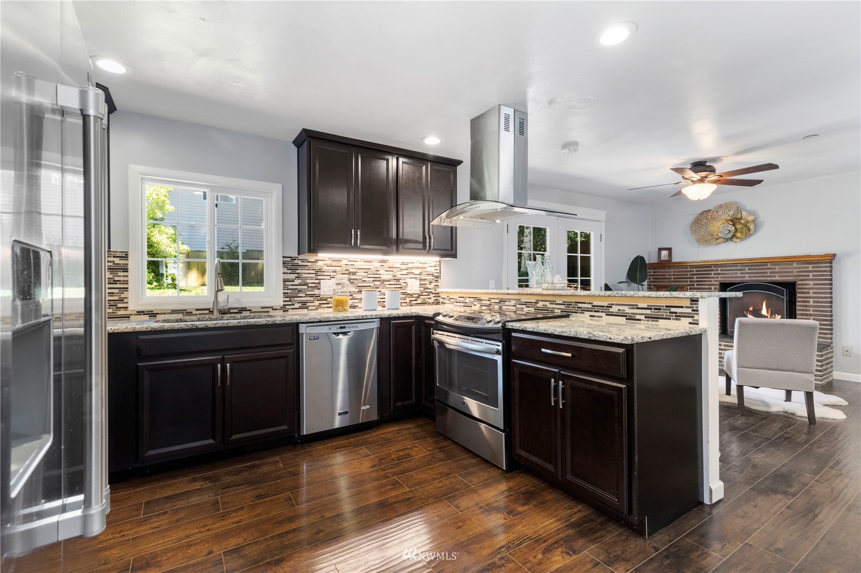 4514 Northeast 17th Place Renton, WA 98059 - Photo 8 of 39 a kitchen with stainless steel appliances granite countertop wooden floors and sink