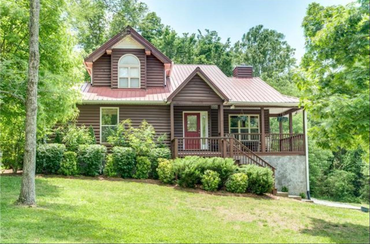 a front view of a house with a yard and trees