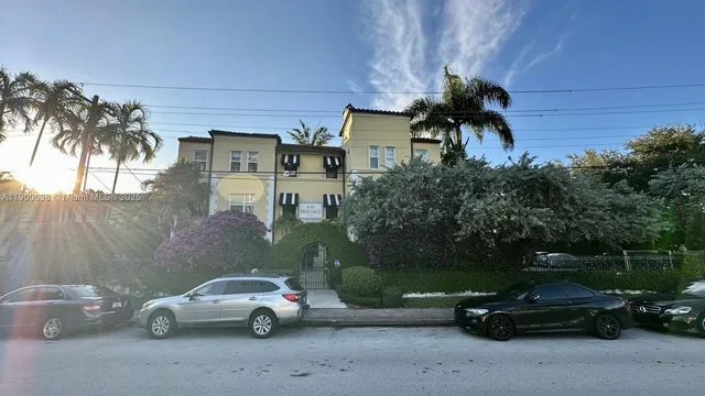 a view of a back yard of the house and cars parked