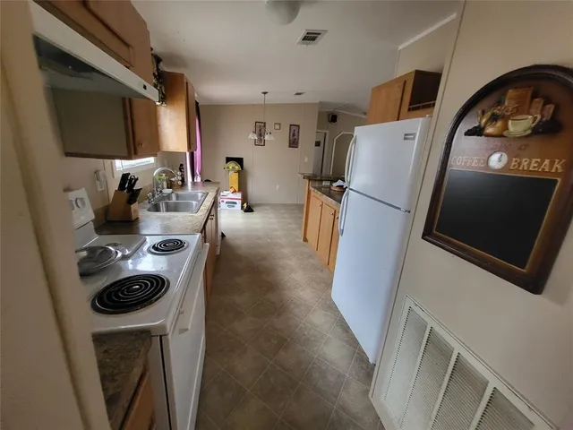 a kitchen with sink a refrigerator and washer