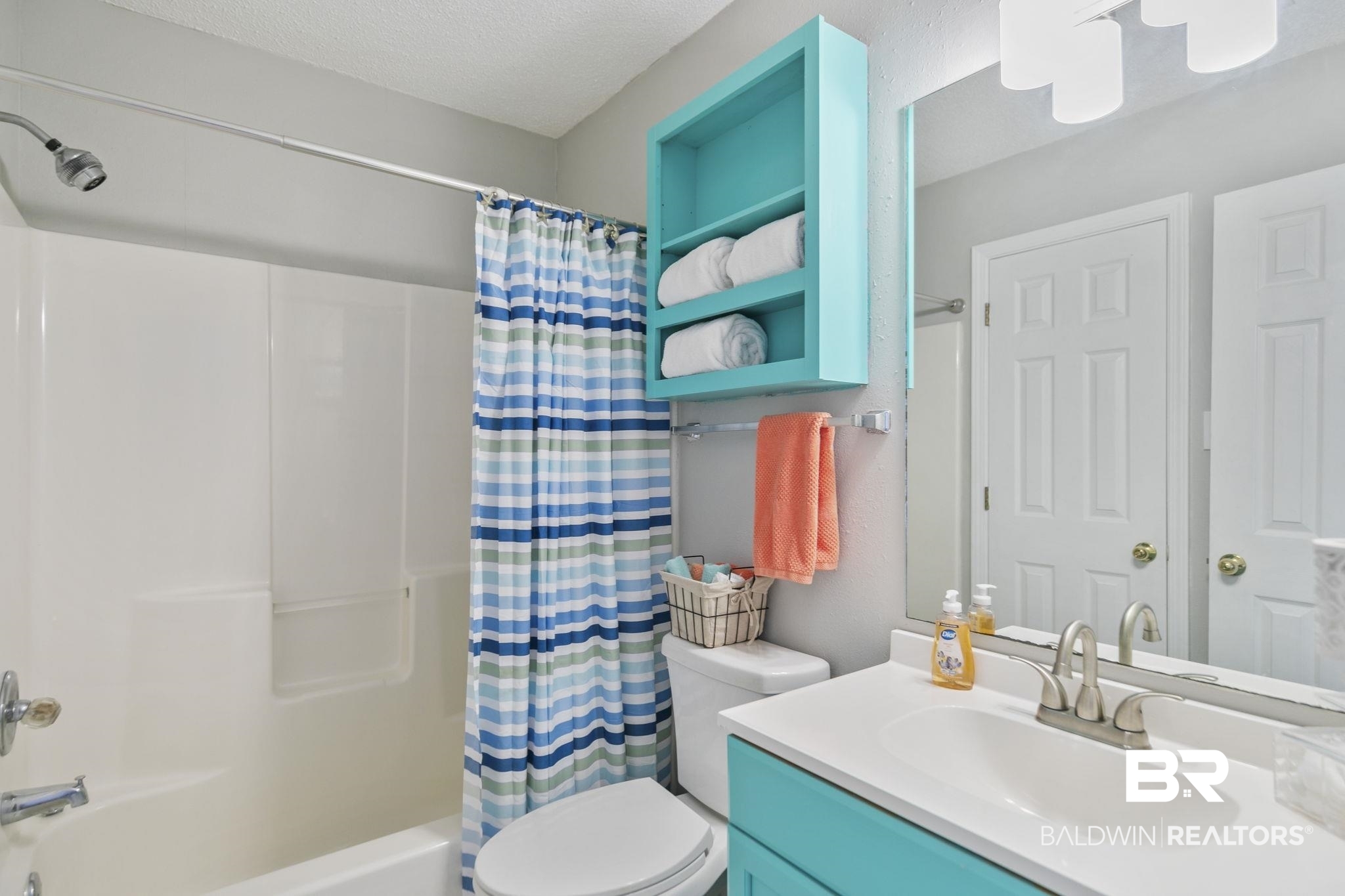25957 Canal Road, Unit 302 Orange Beach, AL 36561 - Photo 16 of 26 Full bathroom featuring a textured ceiling, vanity, shower / bathtub combination with curtain, and toilet