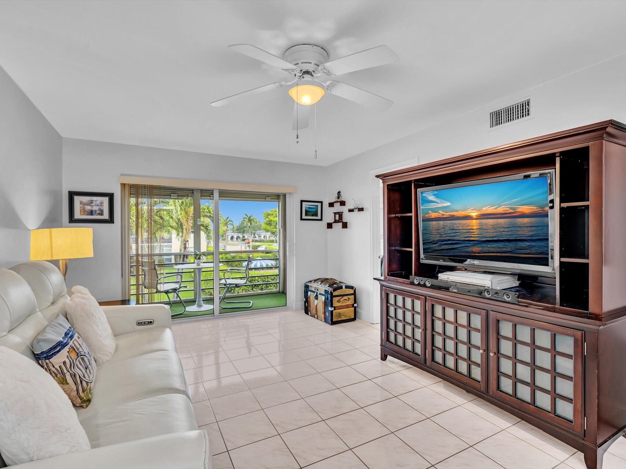 9855 Sandalfoot Boulevard, Unit 320 Boca Raton, FL 33428 - Photo 11 of 23 a living room with furniture and a flat screen tv