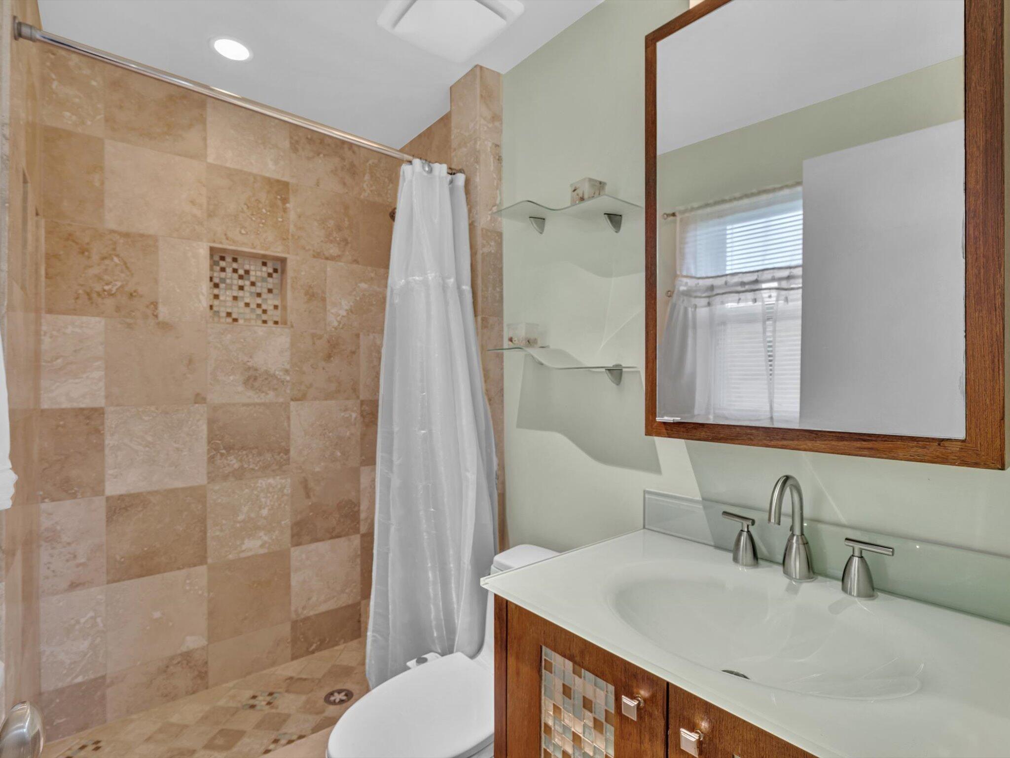 9855 Sandalfoot Boulevard, Unit 320 Boca Raton, FL 33428 - Photo 17 of 23 a bathroom with a granite countertop sink a mirror and a shower