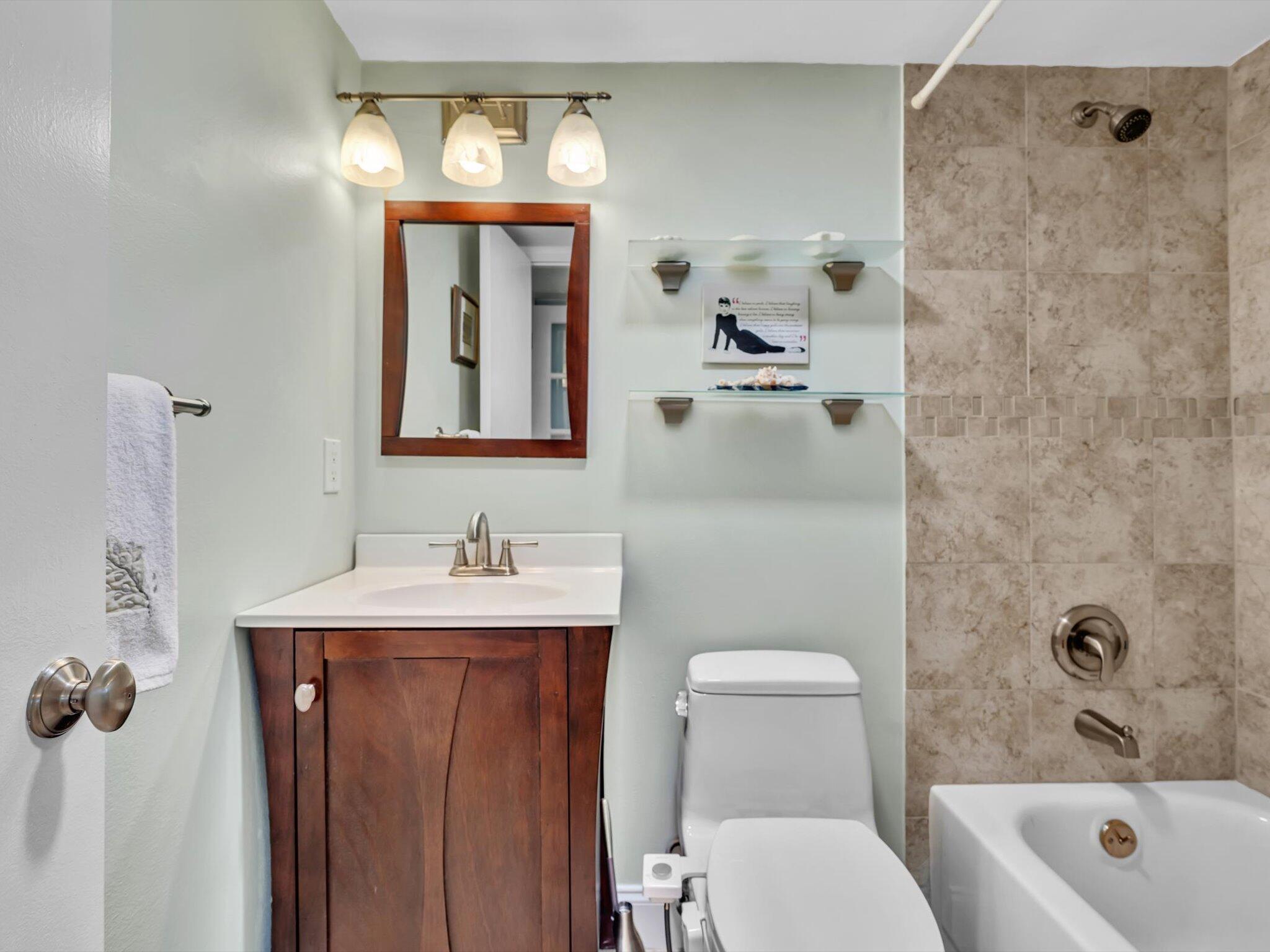 9855 Sandalfoot Boulevard, Unit 320 Boca Raton, FL 33428 - Photo 19 of 23 a bathroom with a toilet a sink and mirror