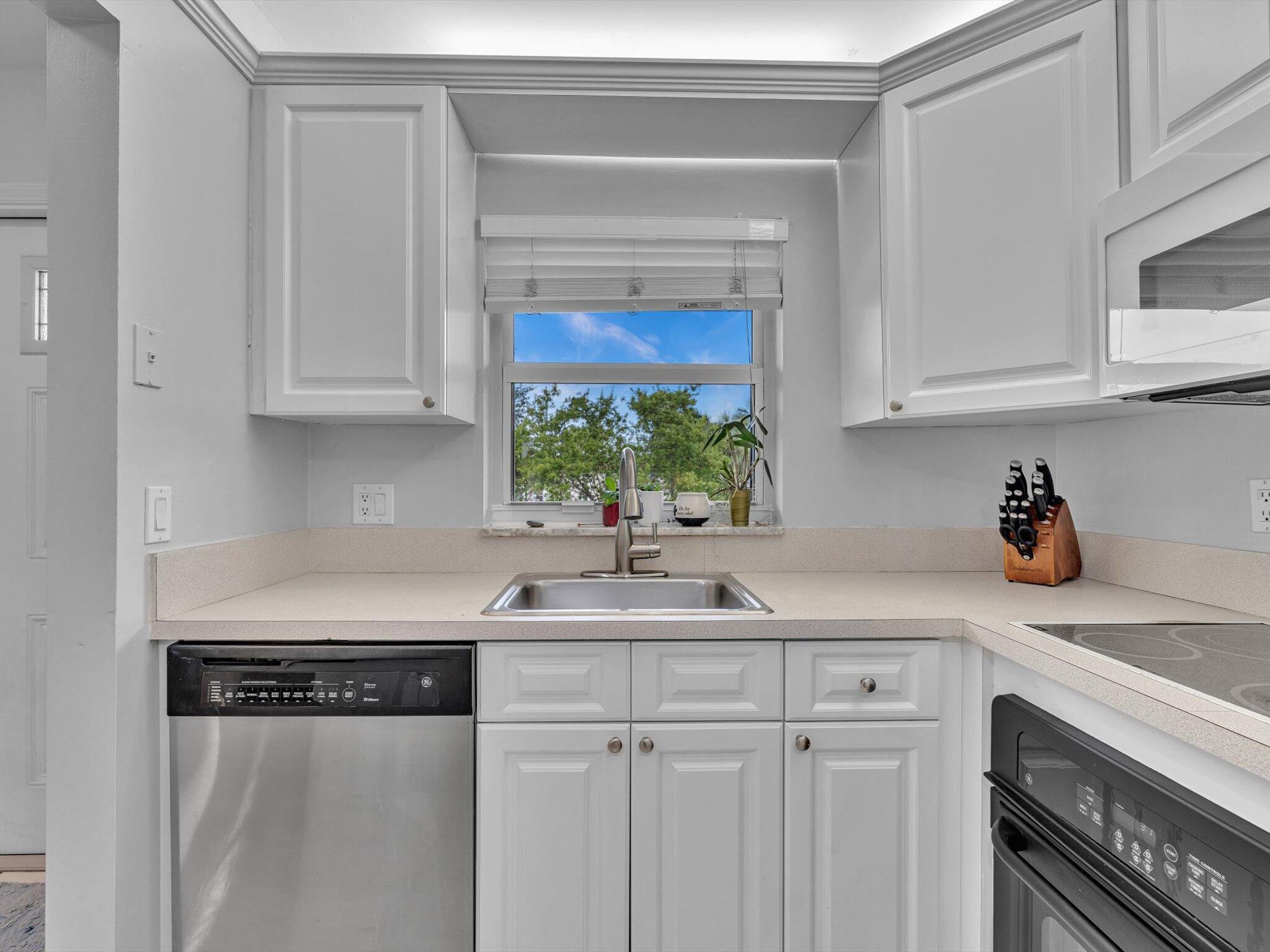 9855 Sandalfoot Boulevard, Unit 320 Boca Raton, FL 33428 - Photo 5 of 23 a kitchen with stainless steel appliances granite countertop a sink a stove and white cabinets