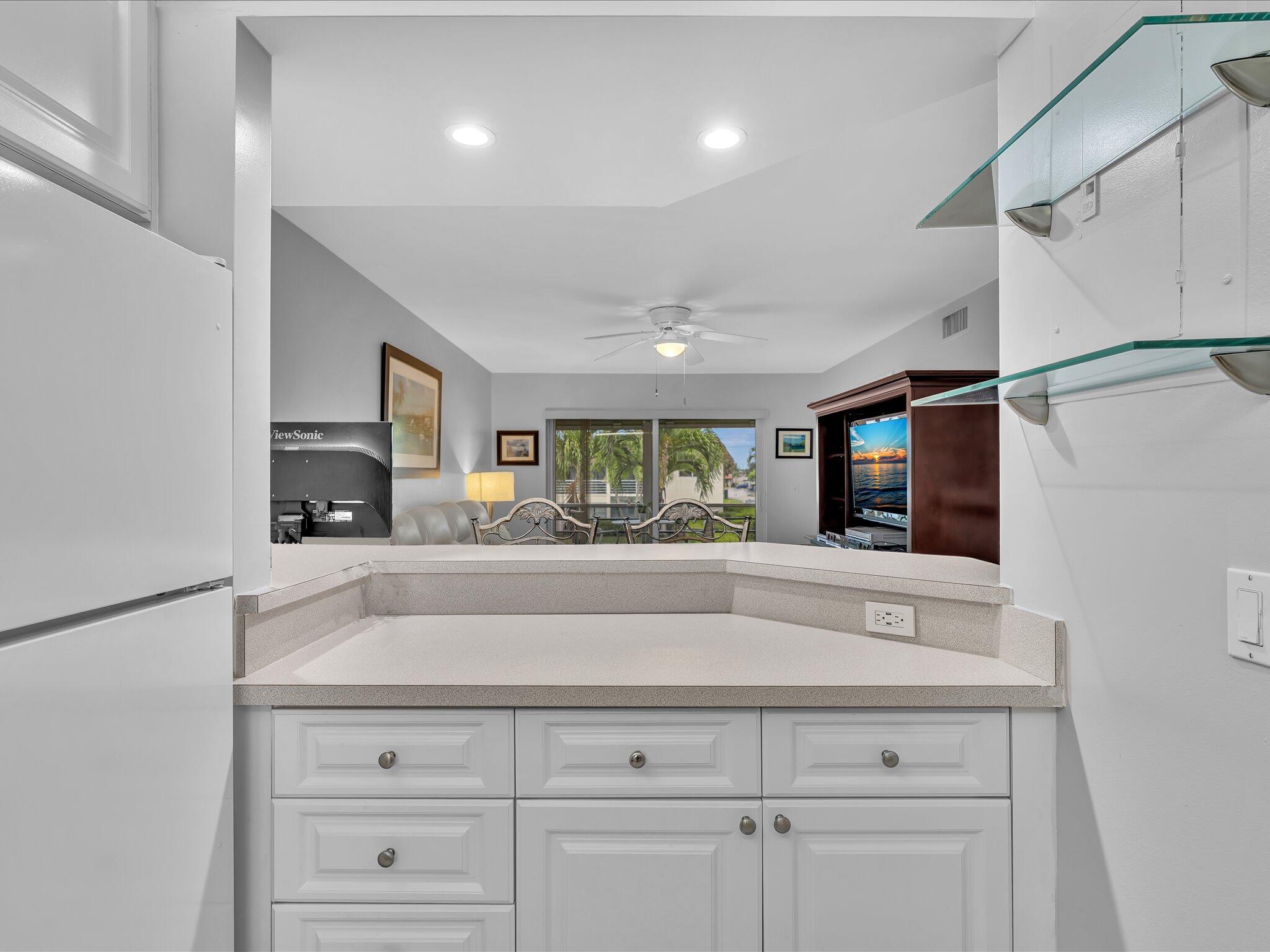 9855 Sandalfoot Boulevard, Unit 320 Boca Raton, FL 33428 - Photo 8 of 23 a living room with hard wood floors and a sink