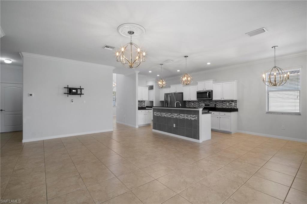 21620 Bella Terra Boulevard Estero, FL 33928 - Photo 13 of 37 a large white kitchen with kitchen island a sink stainless steel appliances and cabinets