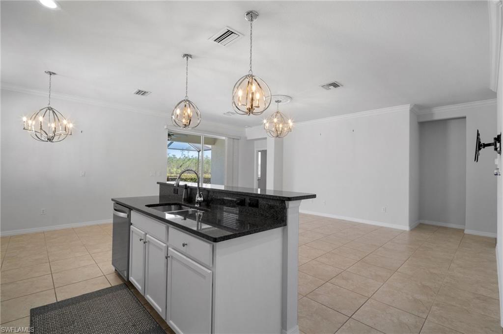 21620 Bella Terra Boulevard Estero, FL 33928 - Photo 4 of 37 a kitchen with a chandelier a island and stainless steel appliances