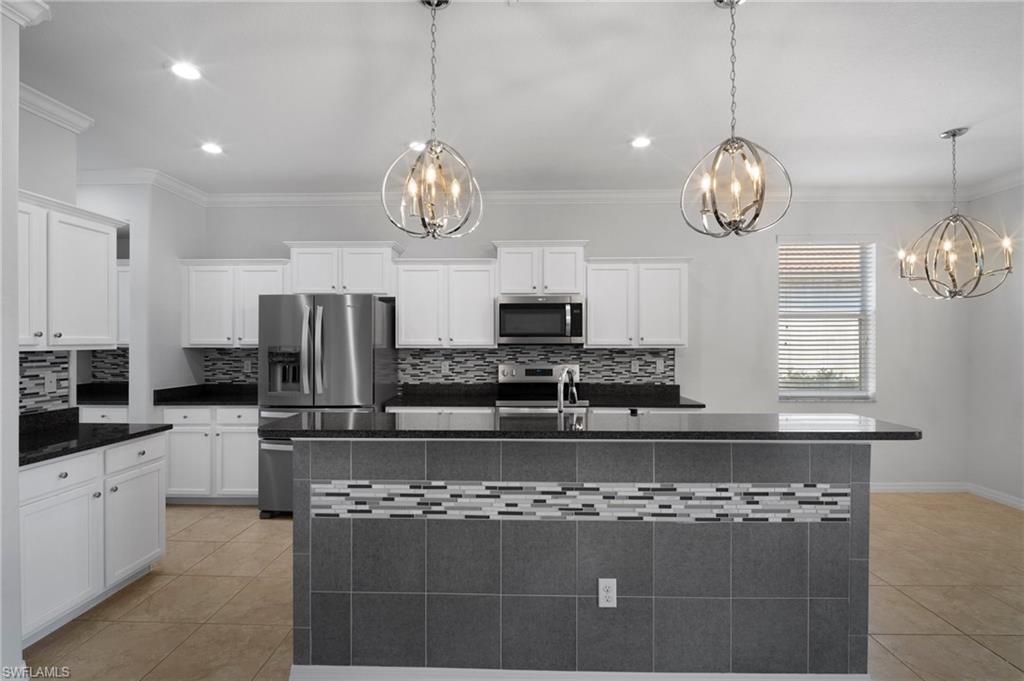 21620 Bella Terra Boulevard Estero, FL 33928 - Photo 5 of 37 a large kitchen with stainless steel appliances granite countertop a stove a refrigerator and a sink