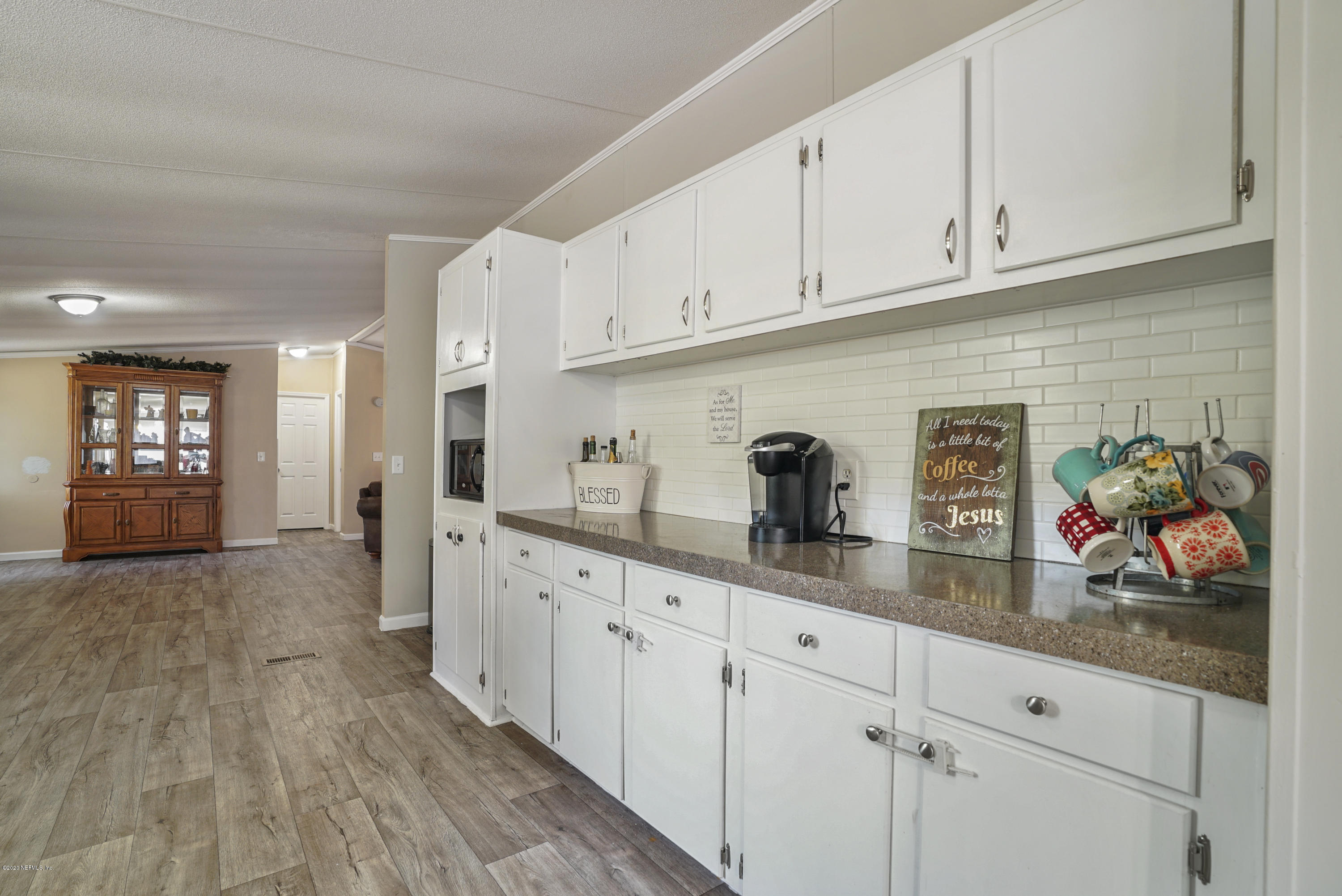 1435 Long Bay Road Middleburg, FL 32068 - Photo 11 of 27 a kitchen with granite countertop white cabinets and white appliances