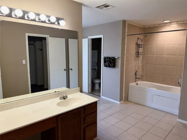 a bathroom with a sink a large mirror and a bathtub