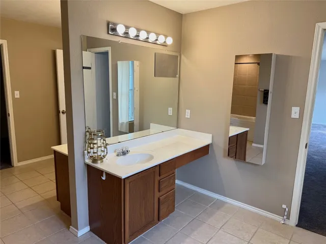 a bathroom with a sink vanity and a mirror