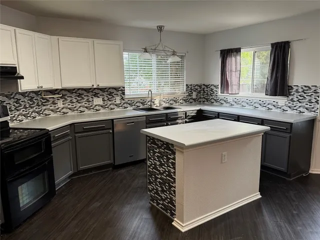 a kitchen with a sink stove and cabinets