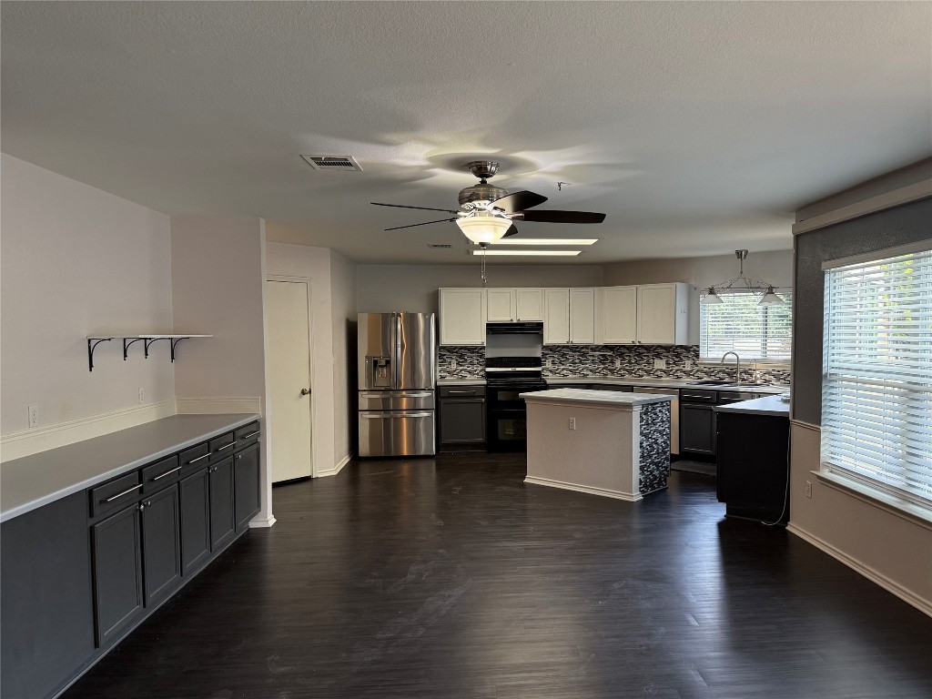 4403 Cisco Valley Drive Round Rock, TX 78664 - Photo 5 of 26 a kitchen with stainless steel appliances kitchen island granite countertop wooden floors and a sink