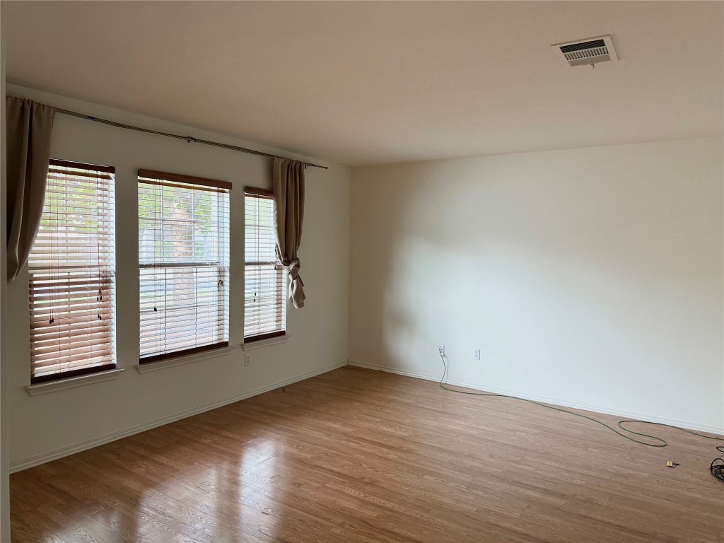4403 Cisco Valley Drive Round Rock, TX 78664 - Photo 10 of 26 an empty room with wooden floor and windows