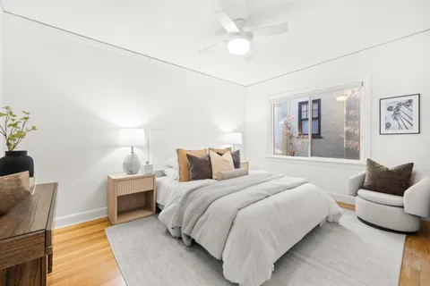 a spacious bedroom with a bed and ceiling fan