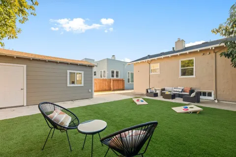 a view of a house with backyard sitting area and garden
