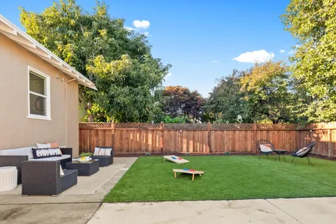 a view of a backyard with table and chairs and a barbeque