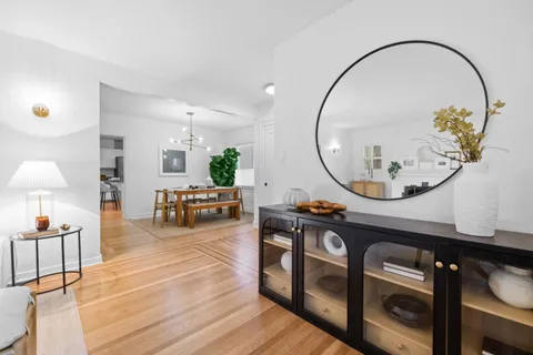 a living room with furniture a mirror and a chandelier