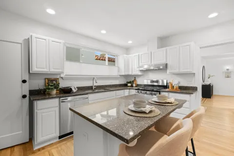 a kitchen with a stove a sink a refrigerator and cabinets