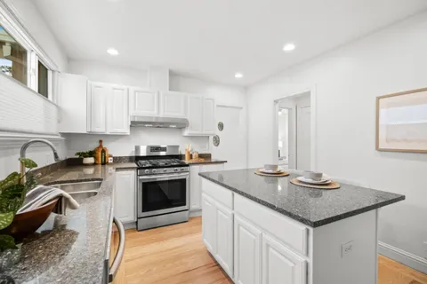 a kitchen with stainless steel appliances granite countertop a stove a sink and a microwave