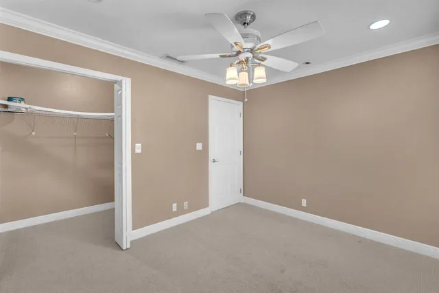 an empty room with a fan & a chandelier fan