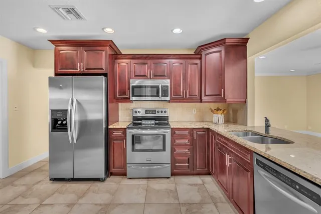 a kitchen with stainless steel appliances granite countertop a refrigerator stove a sink and dishwasher