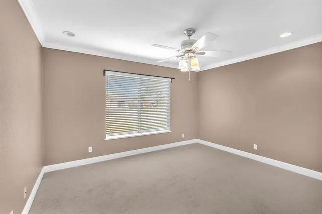 an empty room with a window and a ceiling fan