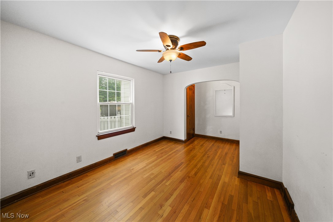 4088 Manchester Road Akron, OH 44319 - Photo 25 of 50 Empty room featuring arched walkways, a ceiling fan, baseboards, and light wood-style floors