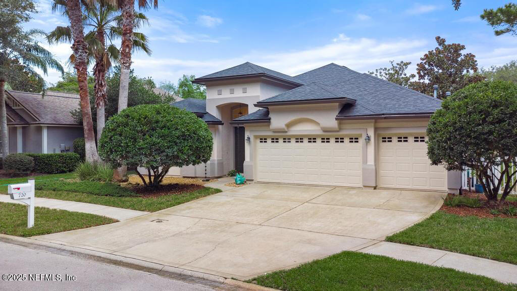 a view of a house with a yard and large tree